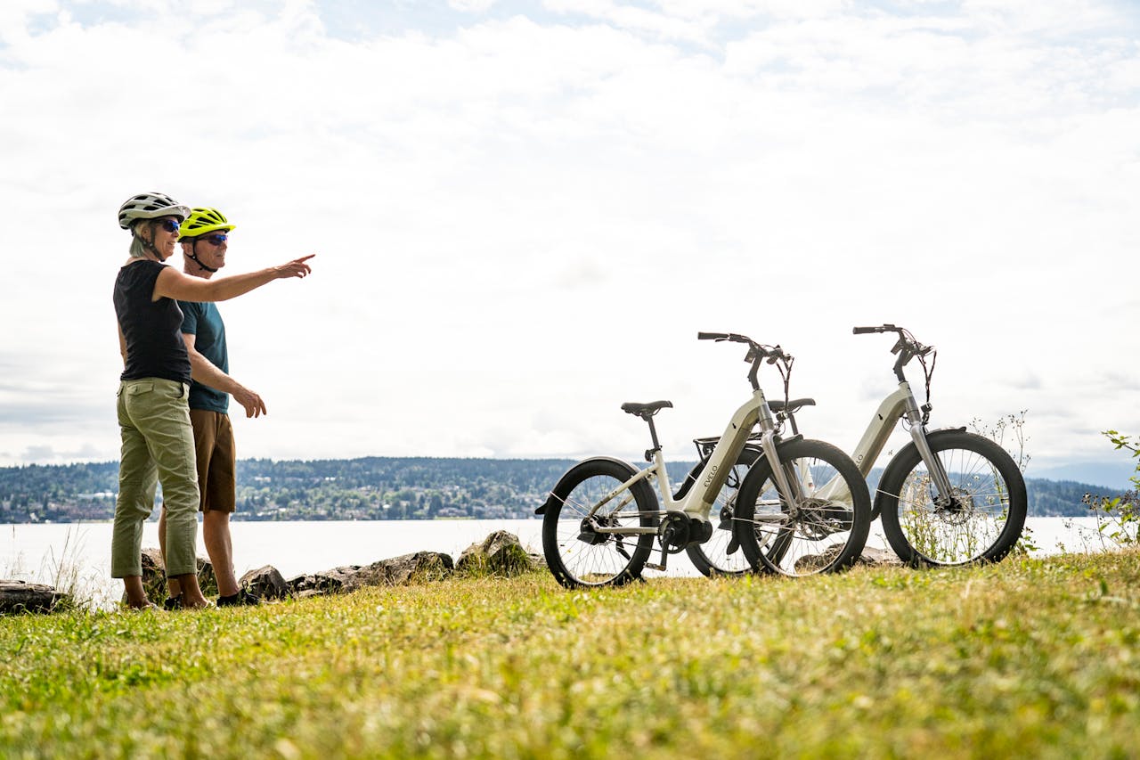 who-we-are A couple in helmets points while enjoying an electric bike adventure near Seattles scenic waterfront.
