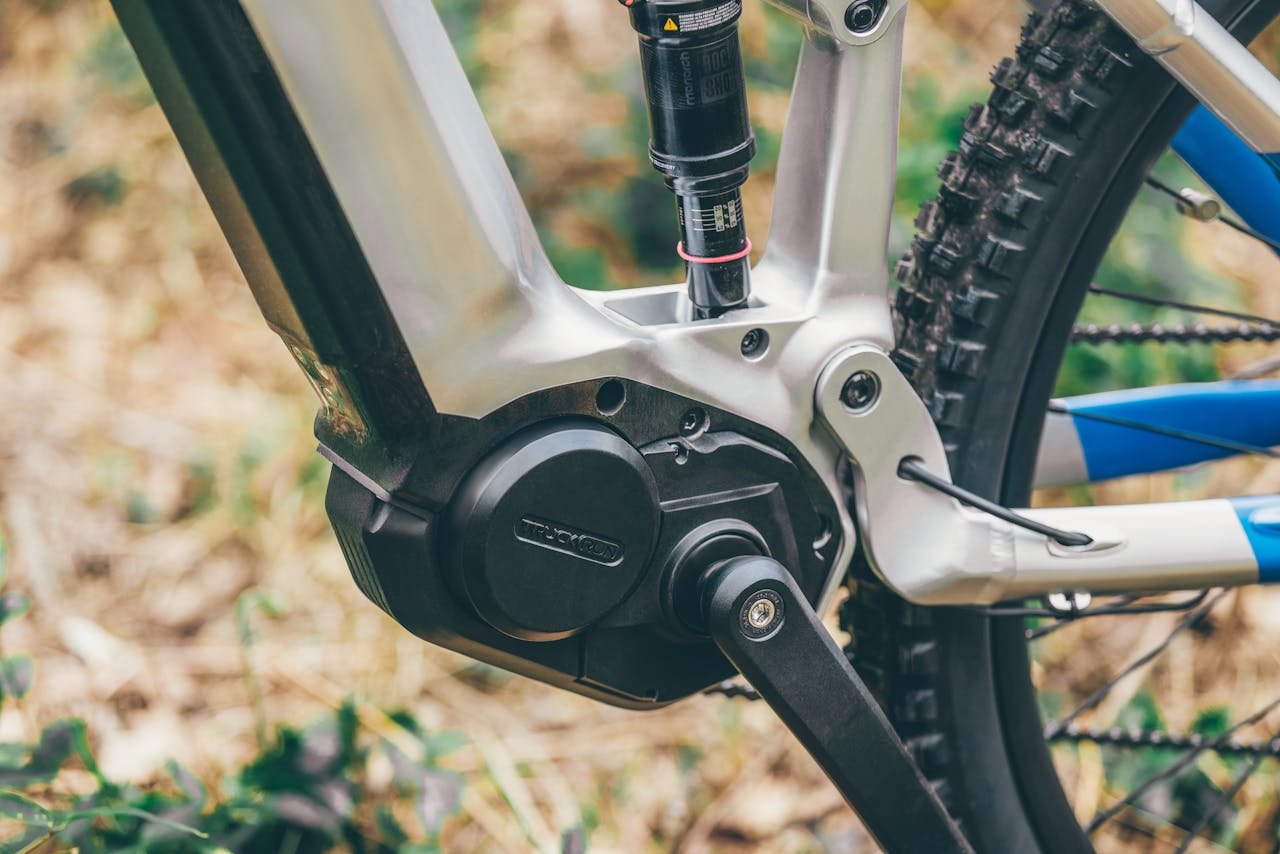 service-04 Detailed view of an electric mountain bike crank arm and frame outdoors.