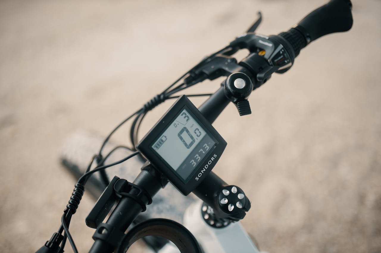 service-02 Detailed view of a bicycles handlebars featuring a digital speedometer and display.
